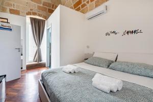 a bedroom with a large bed with towels on it at Tresor 39 in Polignano a Mare