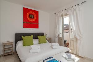a bedroom with a large white bed with green pillows at Estay - Locanda Tartarughino in Porto Rotondo