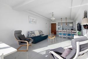 Una sala de estar con un sofá y sillas y una cocina. en Delmar, en Cavacos