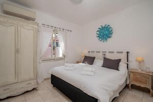 a bedroom with a large bed with white sheets at Estay - Locanda Tartarughino in Porto Rotondo +42 photos