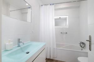 Baño blanco con lavabo y bañera en Delmar, en Cavacos 16 fotos más