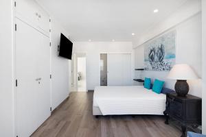 Dormitorio blanco con cama y lámpara en Delmar, en Cavacos