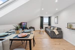 Yello Homes - 4 Guests - 3 Rooms - City View في هيرتسوجيناوراخ: غرفة معيشة مع طاولة وأريكة