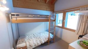 Un dormitorio con literas y una ventana. en Doberts 6, un duplex au pied des montagnes!, en Zinal