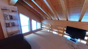 Habitación con TV de pantalla plana en una pared de madera. en Doberts 6, un duplex au pied des montagnes!, en Zinal