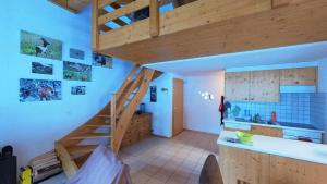 una cocina con una escalera de madera en una casa en Doberts 6, un duplex au pied des montagnes!, en Zinal
