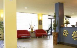 a waiting room with red chairs in a hospital at Hotel Reno in Lido di Savio