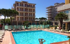 a person standing in a swimming pool in a hotel at Hotel Reno in Lido di Savio