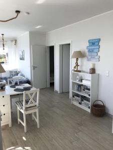 a white room with a desk and a bed at Strandhaus Appartement - Seeschwalbe OG in Fehmarnsund +10 photos