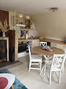 una cucina con tavolo e sedie in una cucina di Golfhues-Simone-Ferienwohnung-Suedbalkon a Wulfen auf Fehmarn