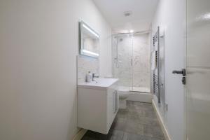 Un baño blanco con lavabo y ducha en 2 Bedroom Spacious Apartment, Free Parking, WiFi, en Gloucester 14 fotos más