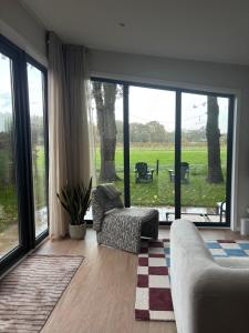 un soggiorno con un divano e una grande finestra di Tiny forest house met vrij uitzicht a Putten