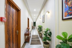 a hallway with potted plants and a wooden door at Hotel Noble Stays in Mohali