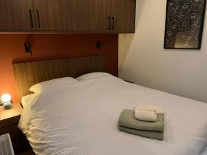 a white bed with two towels on top of it at Tiny forest house met vrij uitzicht in Putten
