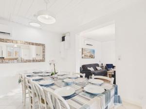 una sala da pranzo bianca con un lungo tavolo e sedie di 400m de la mer - grande maison pour 10 avec jardin a La Tranche-sur-Mer