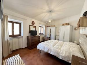 a bedroom with a white bed and a television at La terrazza su Assisi in Assisi