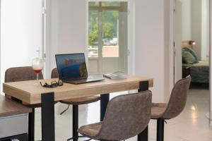 een houten tafel met een laptop en een glas wijn bij GreenPeace - Host Provence in Toulon