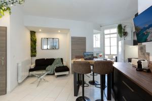een keuken en woonkamer met een tafel en een bank bij GreenPeace - Host Provence in Toulon