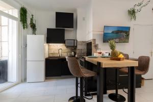 een keuken met een houten tafel en een witte koelkast bij GreenPeace - Host Provence in Toulon +30 foto's