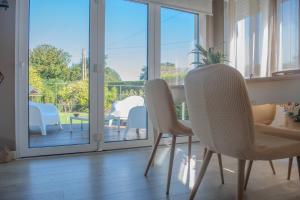 a living room with a table and chairs and a balcony at Porta da Seca casa con jardín y asador Rías Baixas in Poio +31 photos