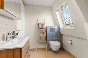een badkamer met toilet, wastafel en raam bij Abcoude city center in Abcoude +29 foto's