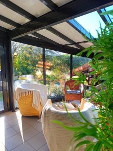 eine Terrasse mit Tisch und Stühlen auf einer Veranda in der Unterkunft Maison d'hôtes Ma Parenthèse in Saint-Christo-en-Jarez