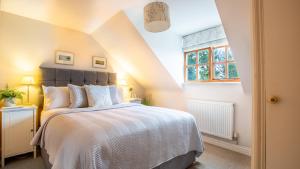 a bedroom with a bed and a window at Teagles Cottage in Stow, EV parking in Stow on the Wold
