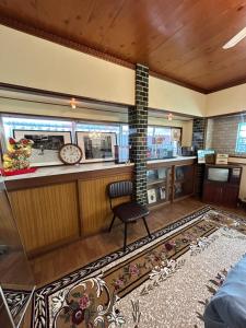 a room with a bar with a clock and a chair at HOSTEL KURIYA OSAKA in Izumi-Sano