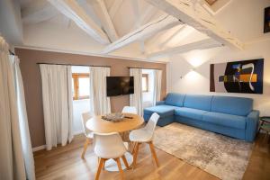 a living room with a blue couch and a table at Hotel Vis à Vis in Trieste