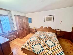 Cozy Apartment - Alverà في كورتينا دامبيتزو: غرفة نوم مع سرير وأرضية خشبية