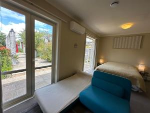 a bedroom with a bed and a chair and a window at Cosy & new CNZhouse with yard in Christchurch