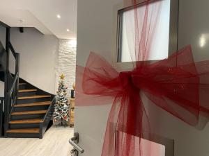a red bow on a wall with a christmas tree at Love House - Maison entière et son jardin - Rare à Paris in Paris