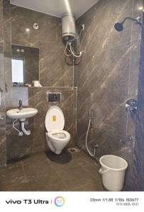 a bathroom with a toilet and a sink at Vilaasitaa Family Suites in Indore