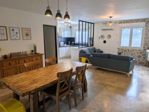 Villa Le Nid du Pont d'Arc في فالون بون دارك: مطبخ وغرفة معيشة مع طاولة وأريكة