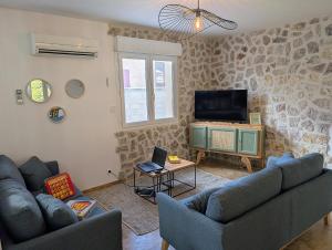 Villa Le Nid du Pont d'Arc في فالون بون دارك: غرفة معيشة مع أريكتين وتلفزيون