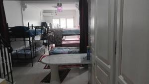 een gang met een kamer met stapelbedden en een tafel bij Dortoir ily in Constantine +1 foto