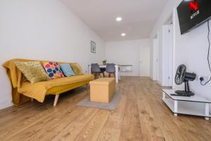 Una sala de estar con un sofá amarillo y una mesa. en Modern 2 Bedroom Apartment, Free Parking, WiFi, en Gloucester