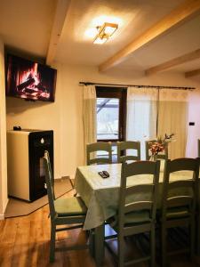 a dining room with a table and chairs and a television at Elixír Guest House in Izvoare