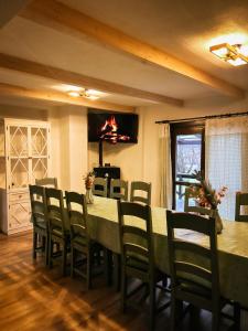 a dining room with a long table and chairs at Elixír Guest House in Izvoare