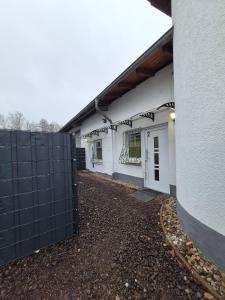 un edificio bianco con una recinzione nera accanto di Cozy 2-bed Room With Kitchen a Rehlingen