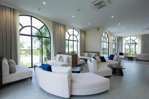 Xóm TramPolaris Resort & Spa的客厅配有白色的沙发、桌子和窗户