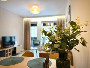 un vaso di fiori su un tavolo in soggiorno di Prywatny Parking przy Starówce Apartament Logan by Rentoom a Toruń