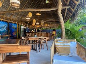 een restaurant met houten tafels en stoelen en een boom bij Bahia Selvatica Lodge in Uvita