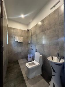 a bathroom with a toilet and a sink at The Corbett Niyas in Rāmnagar +34 photos