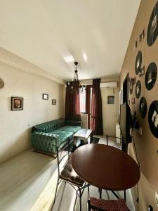 un soggiorno con un divano verde e un tavolo di Уютная и светлая квартира с видом на горы a Tbilisi City