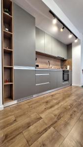 een lege keuken met houten vloeren en roestvrijstalen apparaten bij Sara Apartament in Craiova