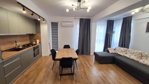 een keuken en een woonkamer met een tafel en een bank bij Sara Apartament in Craiova +21 foto's