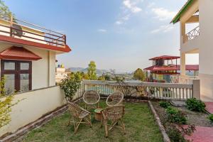 un patio con due sedie e un tavolo in un cortile di Lakeview House 7 mins to Bhimtal Lake3BHK2Bath a Bhimtal