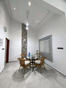 a dining room with a glass table and chairs at Appartement de luxe avec piscine in Abomey-Calavi