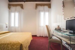 a bedroom with a bed and a desk with a computer at Locanda Ca' Lucrezia in Venice +24 photos
